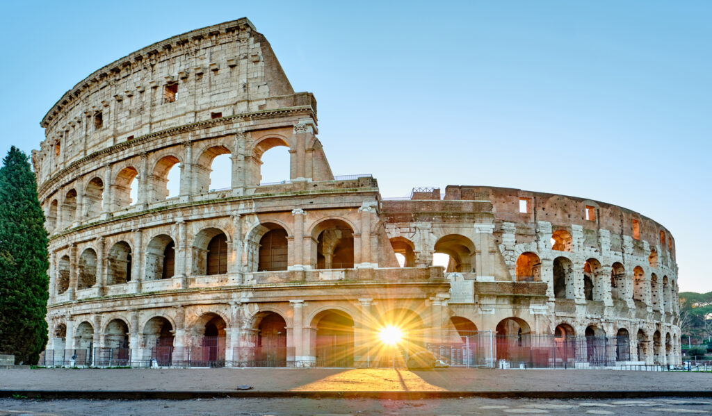 Colosseum at sunrise in Rome, Italy - Iconic Landmarks in Italy with sunlight shining through arches