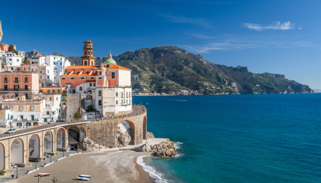 A picturesque view of Atrani on the Amalfi Coast, showcasing the charming town perched on cliffs above the turquoise waters, making it one of the best beaches in Italy.