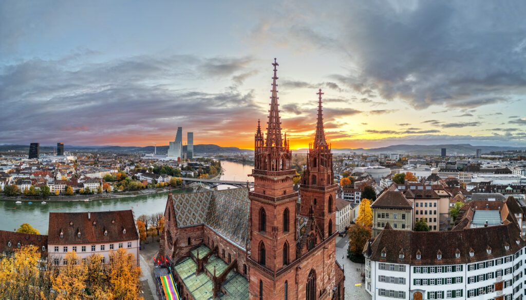 Aerial sunset view of Basel, best Swiss city, featuring Gothic cathedral and Rhine River
