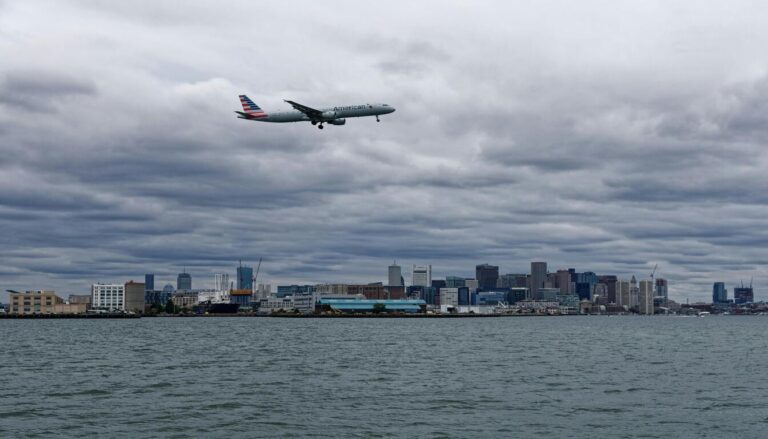 Plane flying over Boston skyline before boston to miami flights